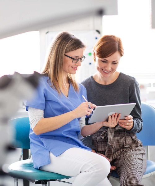 a-dentist-talking-to-woman-in-dentist-surgery-a-d-CM8VQGB.jpg